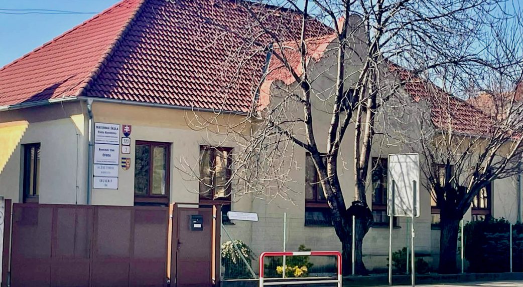 A gyerek van középen, egyik feléről a szülő, másik feléről az óvónő fogja a kezét